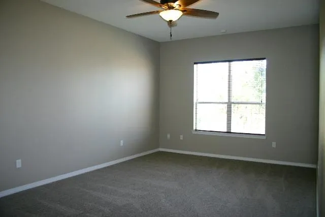 a view of an empty room with a ceiling fan