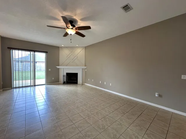 an empty room with windows and fireplace