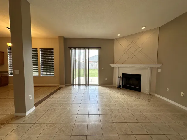 a view of an empty room with a fireplace and a window
