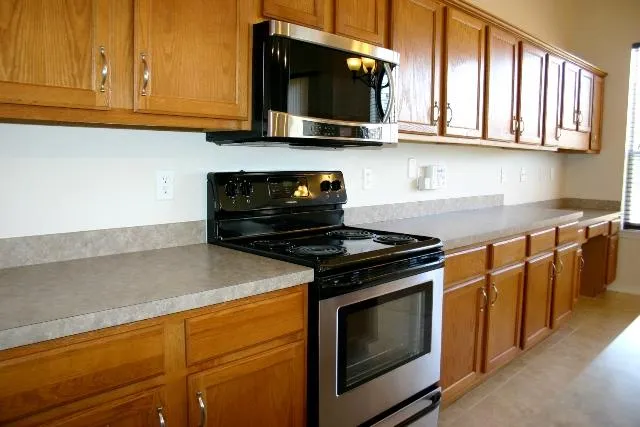 a kitchen with stainless steel appliances granite countertop a stove microwave and oven
