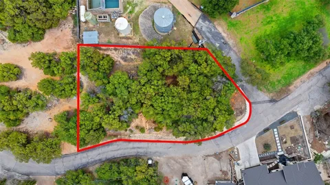 an aerial view of ocean and residential houses with outdoor space