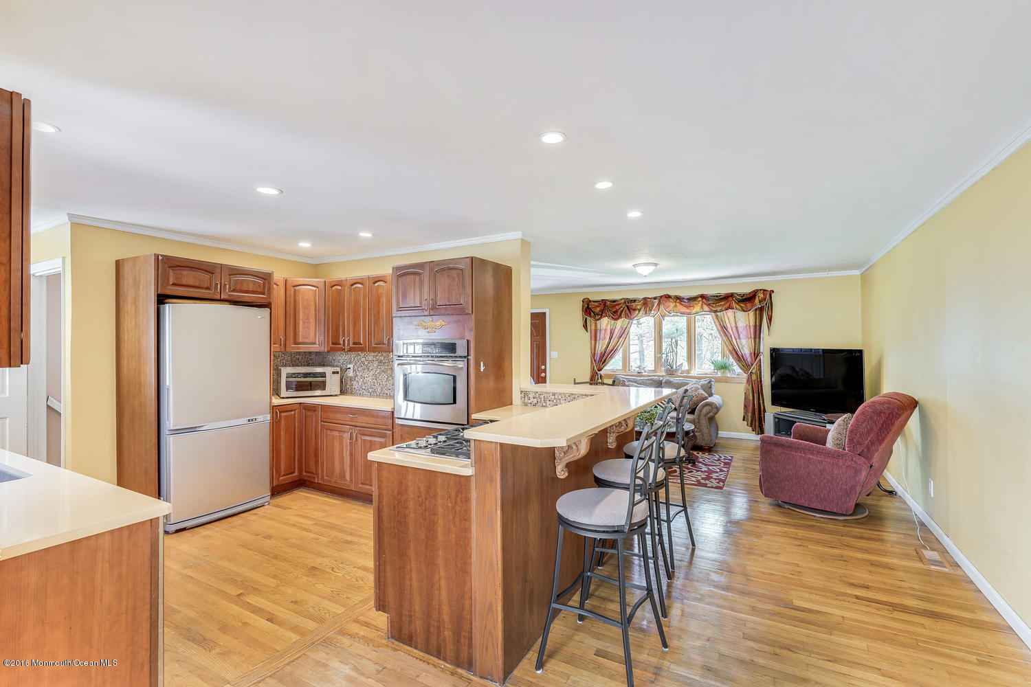 9 Chestnut Ridge Road Holmdel, NJ 07733 - Photo 21 of 39 a kitchen with stainless steel appliances kitchen island granite countertop a refrigerator a stove a sink a dining table and chairs with wooden floor