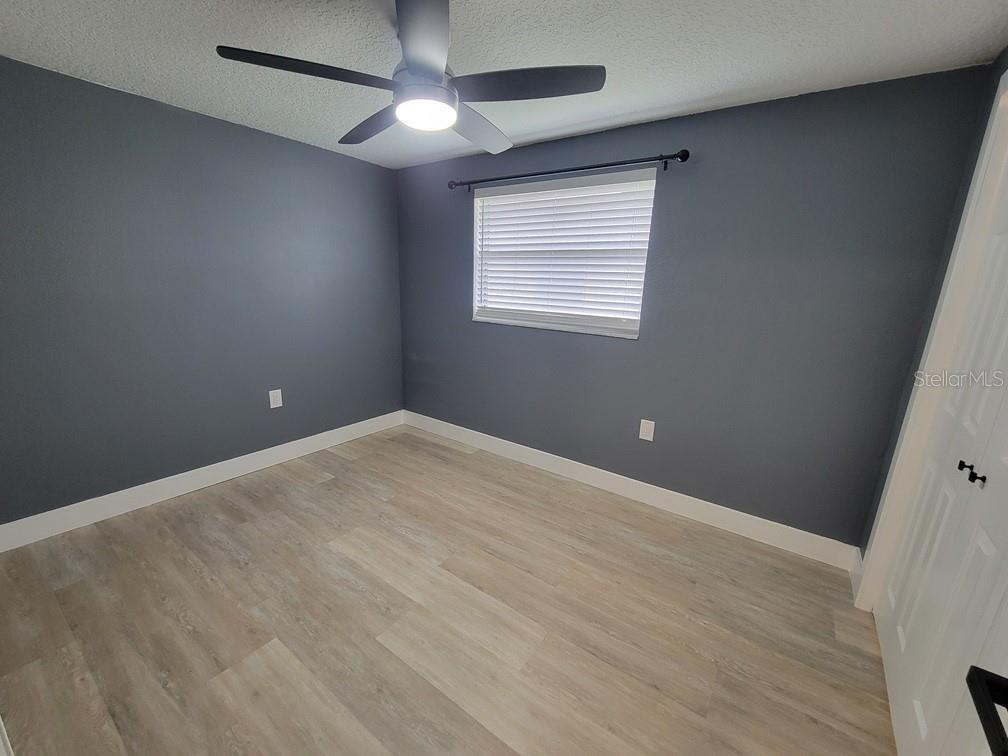 4944 Elkner Street New Port Richey, FL 34652 - Photo 12 of 24 an empty room with wooden floor and windows