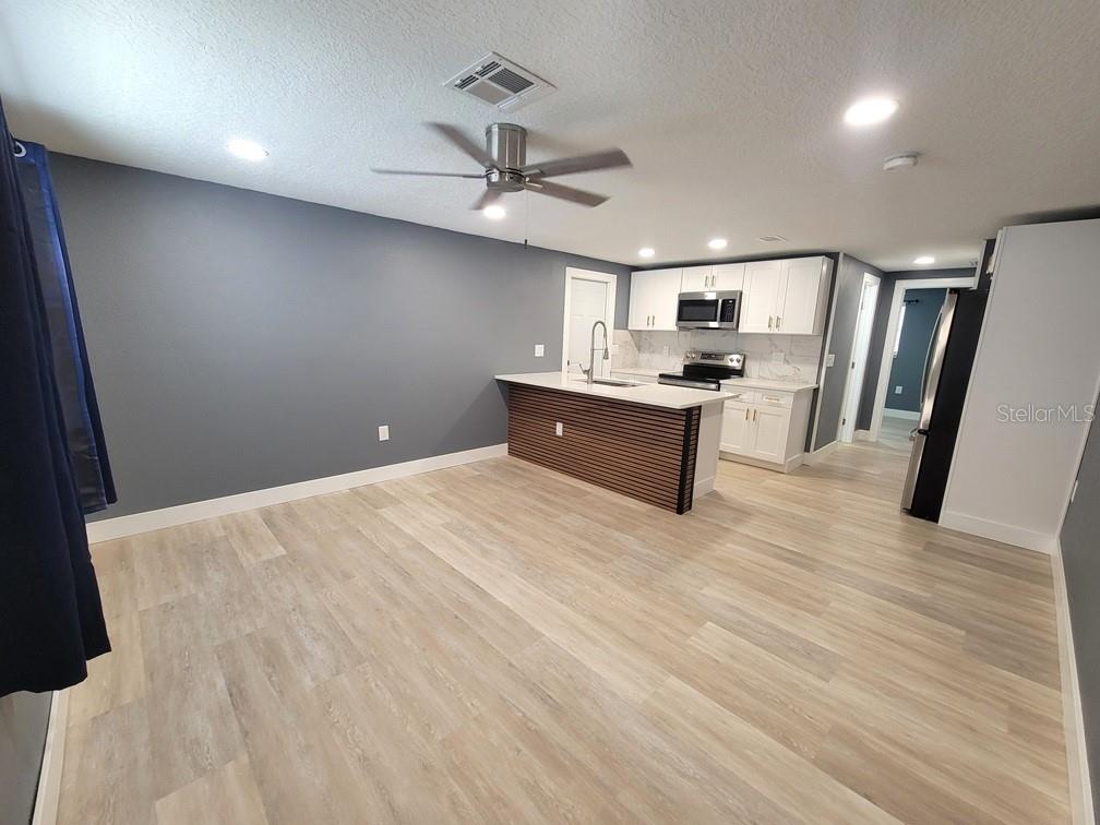 4944 Elkner Street New Port Richey, FL 34652 - Photo 4 of 24 a large kitchen with a stove and wooden floor