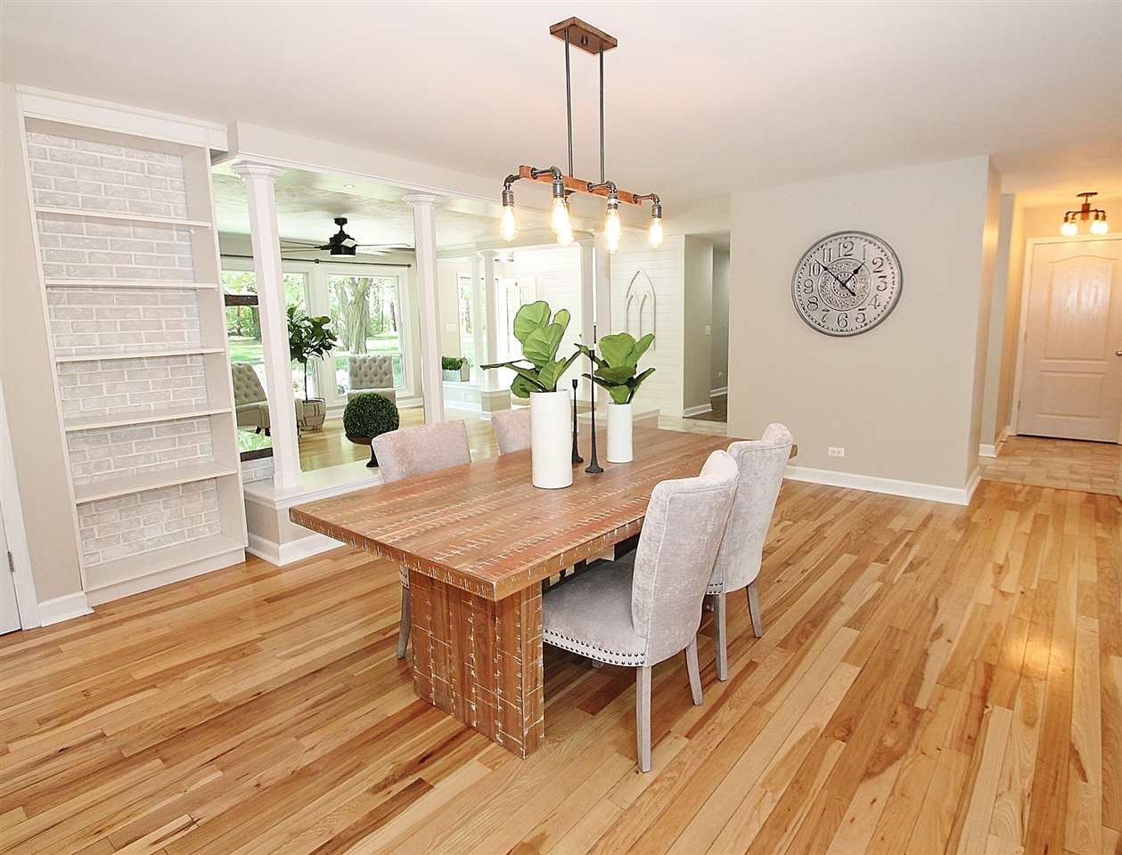 8372 Spring Creek Road Rockford, IL 61114 - Photo 11 of 25 a dining room with wooden floor a chandelier a wooden table and chairs