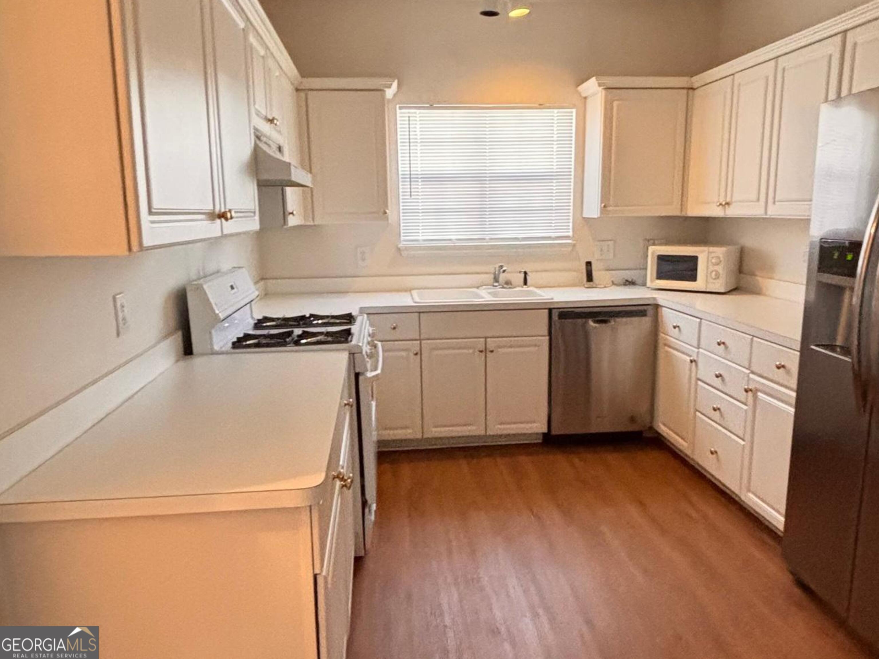 474 Fraser Street Southeast Atlanta, GA 30312 - Photo 21 of 21 a kitchen with stainless steel appliances granite countertop white cabinets sink and a dishwasher next to a window