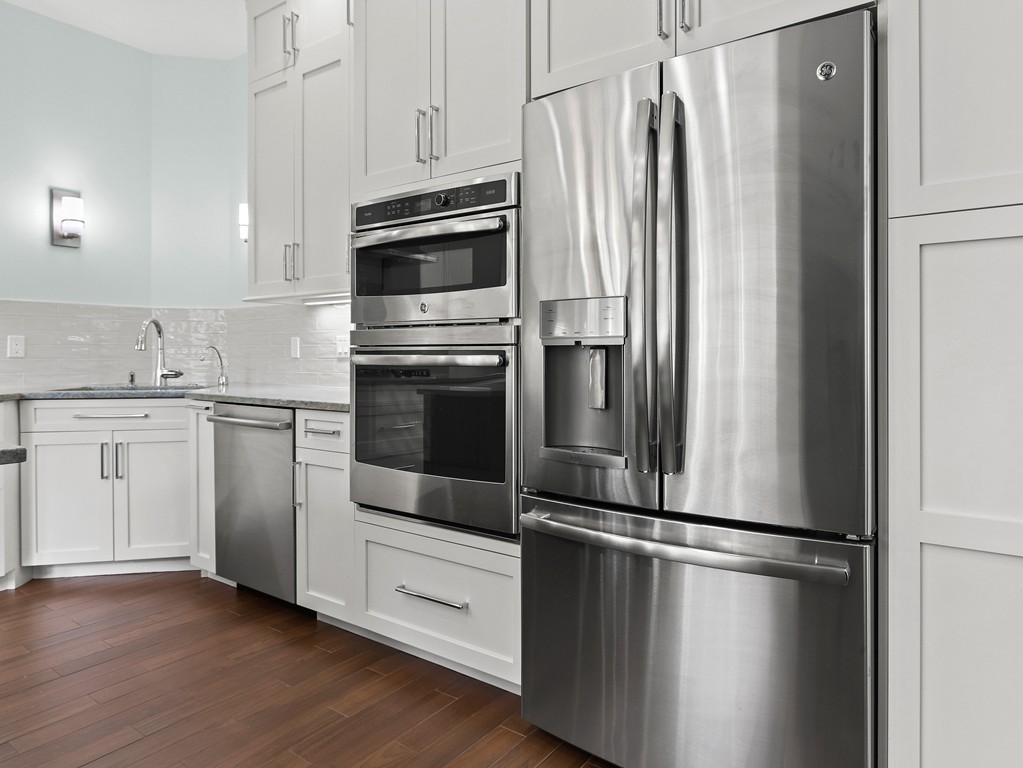 63 Herrick Road, Unit 2 Newton, MA 02459 - Photo 14 of 38 a kitchen with stainless steel appliances a refrigerator and cabinets