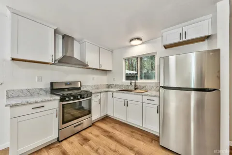 a kitchen with stainless steel appliances a refrigerator sink and cabinets