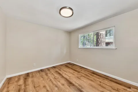 a view of a room with wooden floor and window