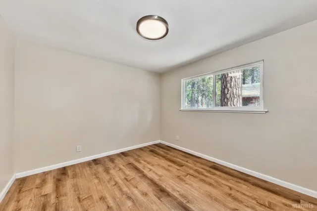 a view of a room with wooden floor and window