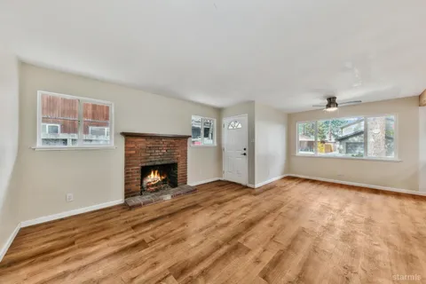 a view of an empty room with a fireplace and a window