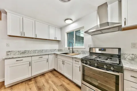 a kitchen with granite countertop cabinets stainless steel appliances and sink