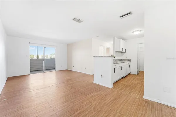 a view of a kitchen with wooden floor and windows