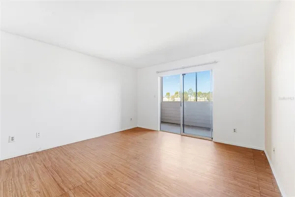 an empty room with wooden floor and sliding door