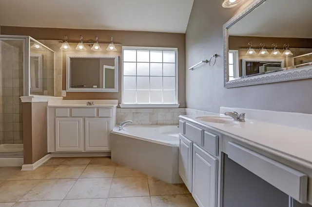 a bathroom with a tub sink and mirror
