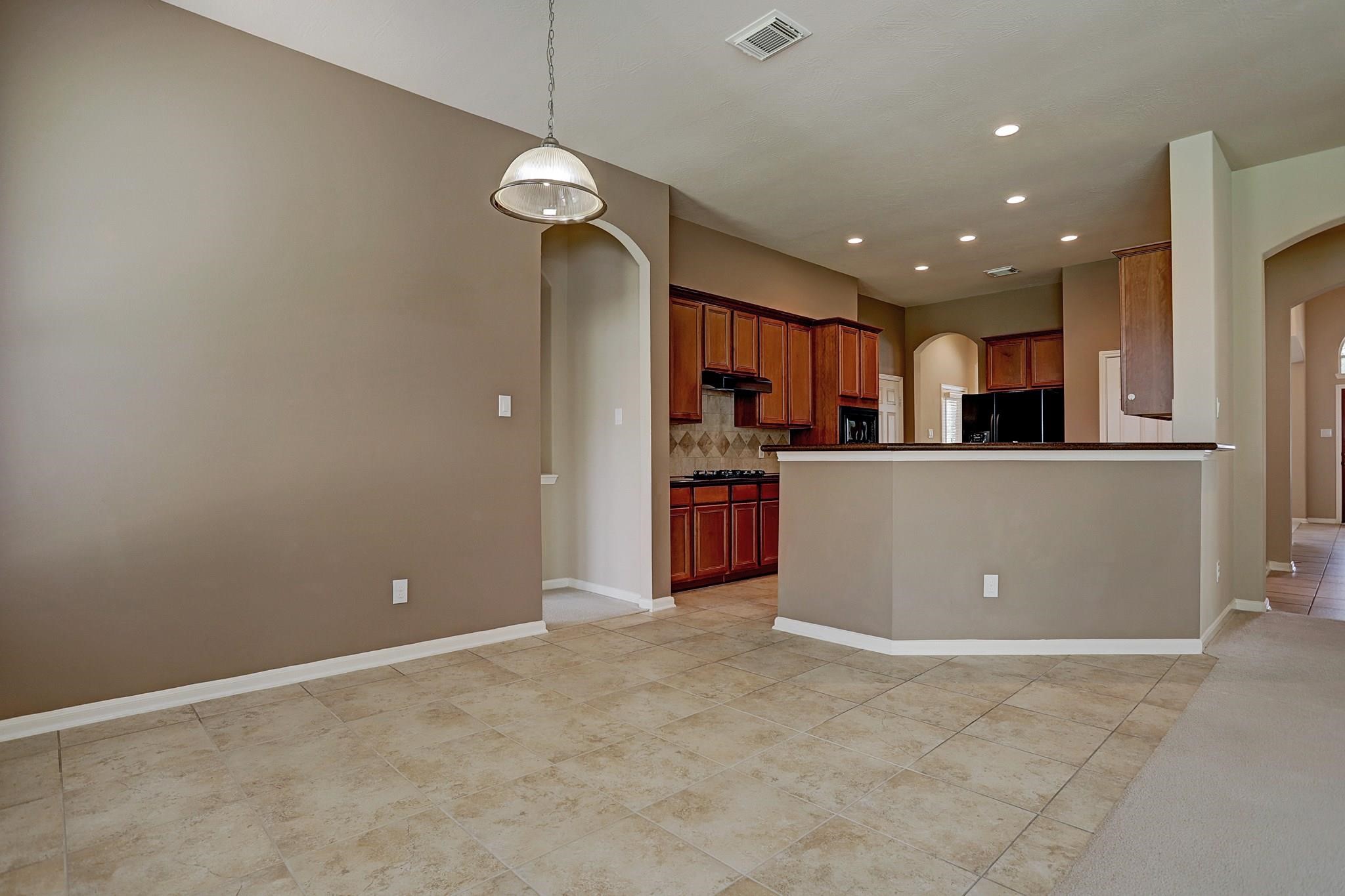 2118 Great Prairie Lane Katy, TX 77494 - Photo 10 of 24 a view of a kitchen with a refrigerator wooden floor and a kitchen