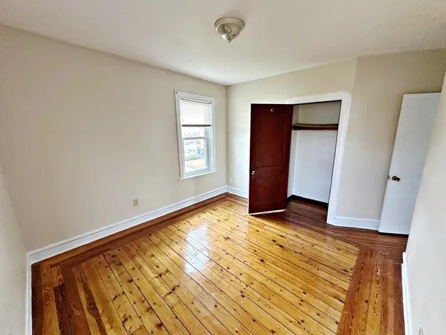 a view of a room with wooden floor and a window