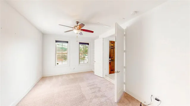 a view of a livingroom with a ceiling fan and window