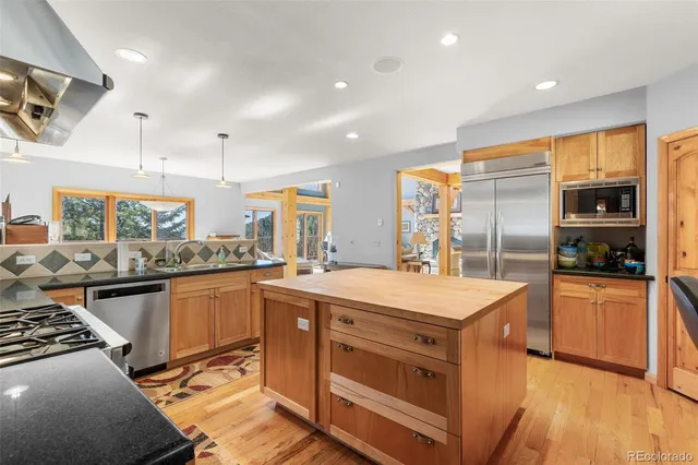a kitchen with stainless steel appliances granite countertop a stove and a refrigerator