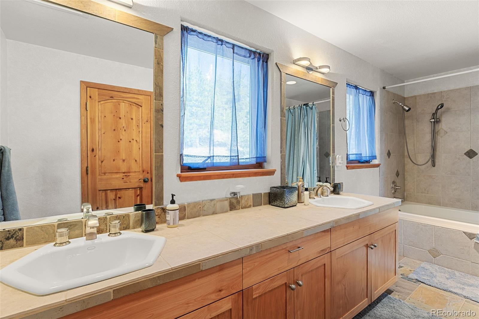 13445 Baird Road Conifer, CO 80433 - Photo 44 of 50 a bathroom with a double vanity sink mirror double and shower