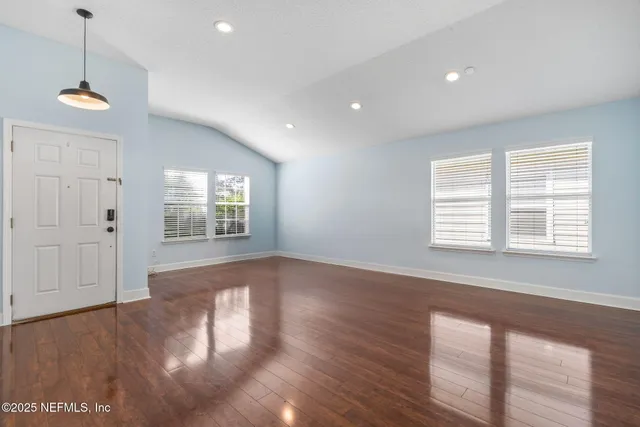 a view of empty room with wooden floor