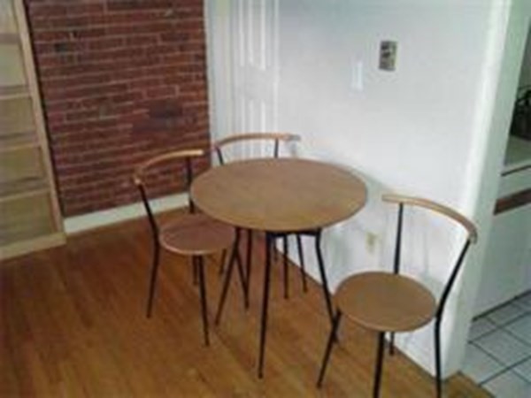 a view of a room with table and chairs