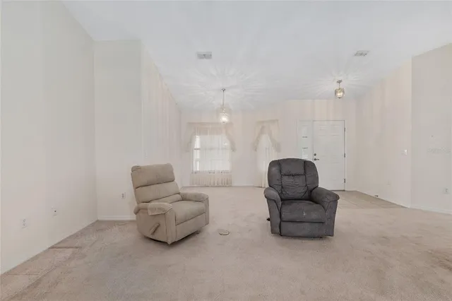 a living room with furniture and a floor to ceiling window