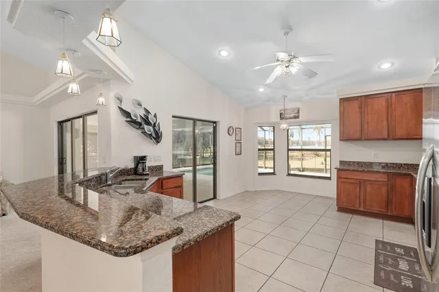 a kitchen with granite countertop wooden cabinets and a stove top oven
