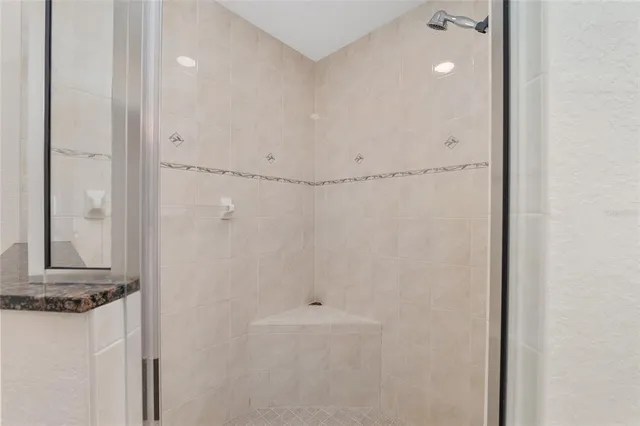 an empty room with chandelier fan and windows