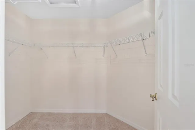 an empty room with chandelier fan and windows