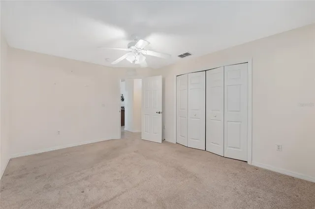 a view of a big room with windows and chandelier fan