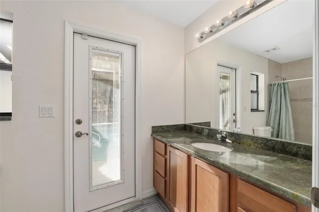 a view of a house with a yard balcony and wooden fence