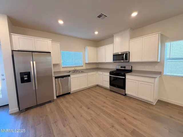a kitchen with stainless steel appliances a refrigerator sink and microwave