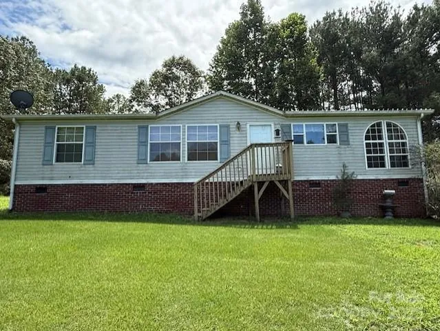 a view of a house with a yard and sitting area