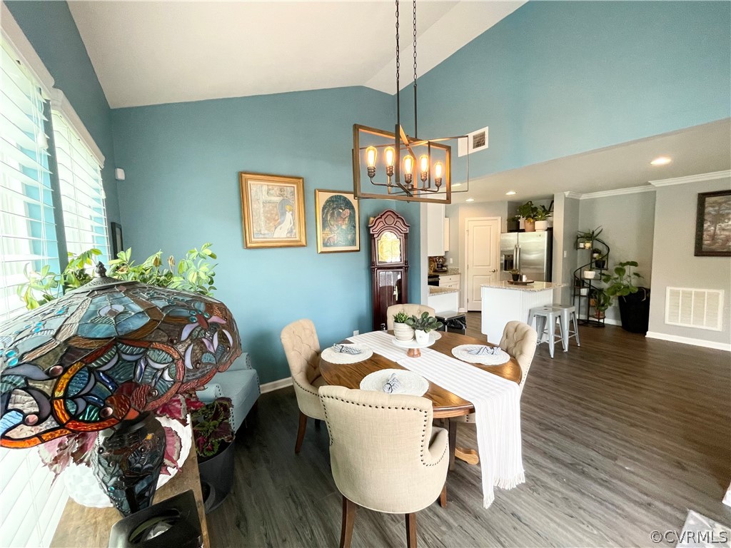 10219 Sandy Ridge Drive Chesterfield, VA 23832 - Photo 12 of 28 a dining room with wooden floor a chandelier a wooden table and chairs