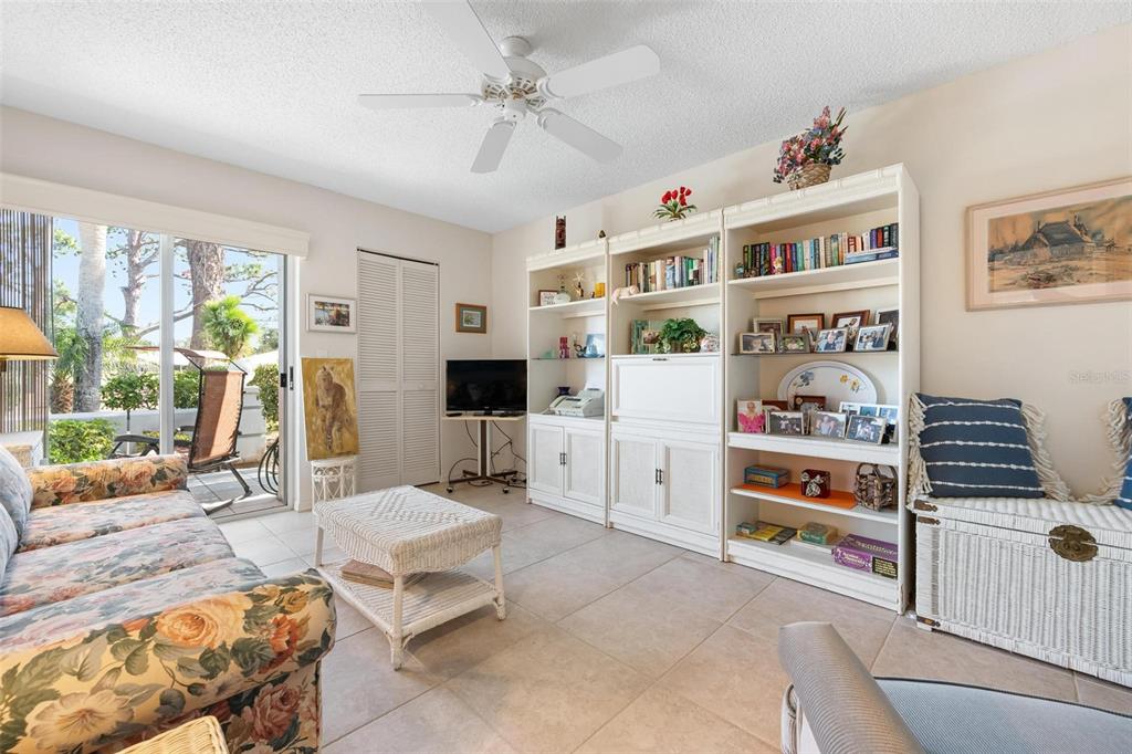 270 Cerromar Way South, Unit 57 Venice, FL 34293 - Photo 26 of 81 a living room with furniture a flat screen tv and a floor to ceiling window