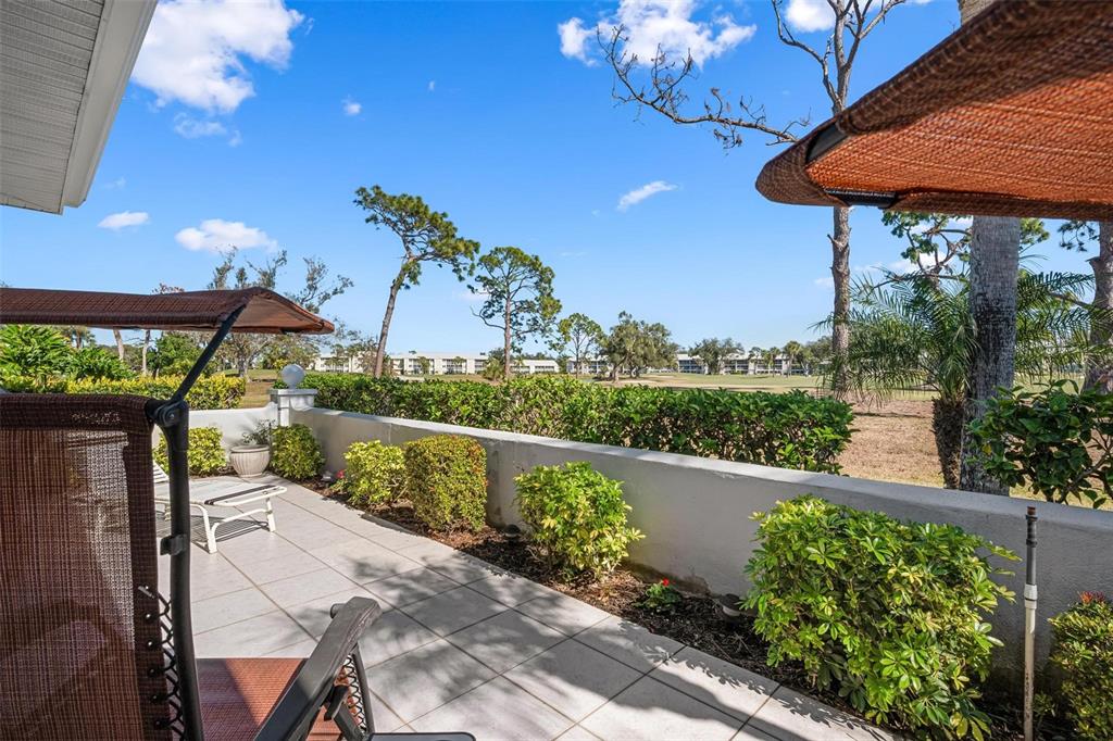 270 Cerromar Way South, Unit 57 Venice, FL 34293 - Photo 34 of 81 a view of a patio with table and chairs under an umbrella