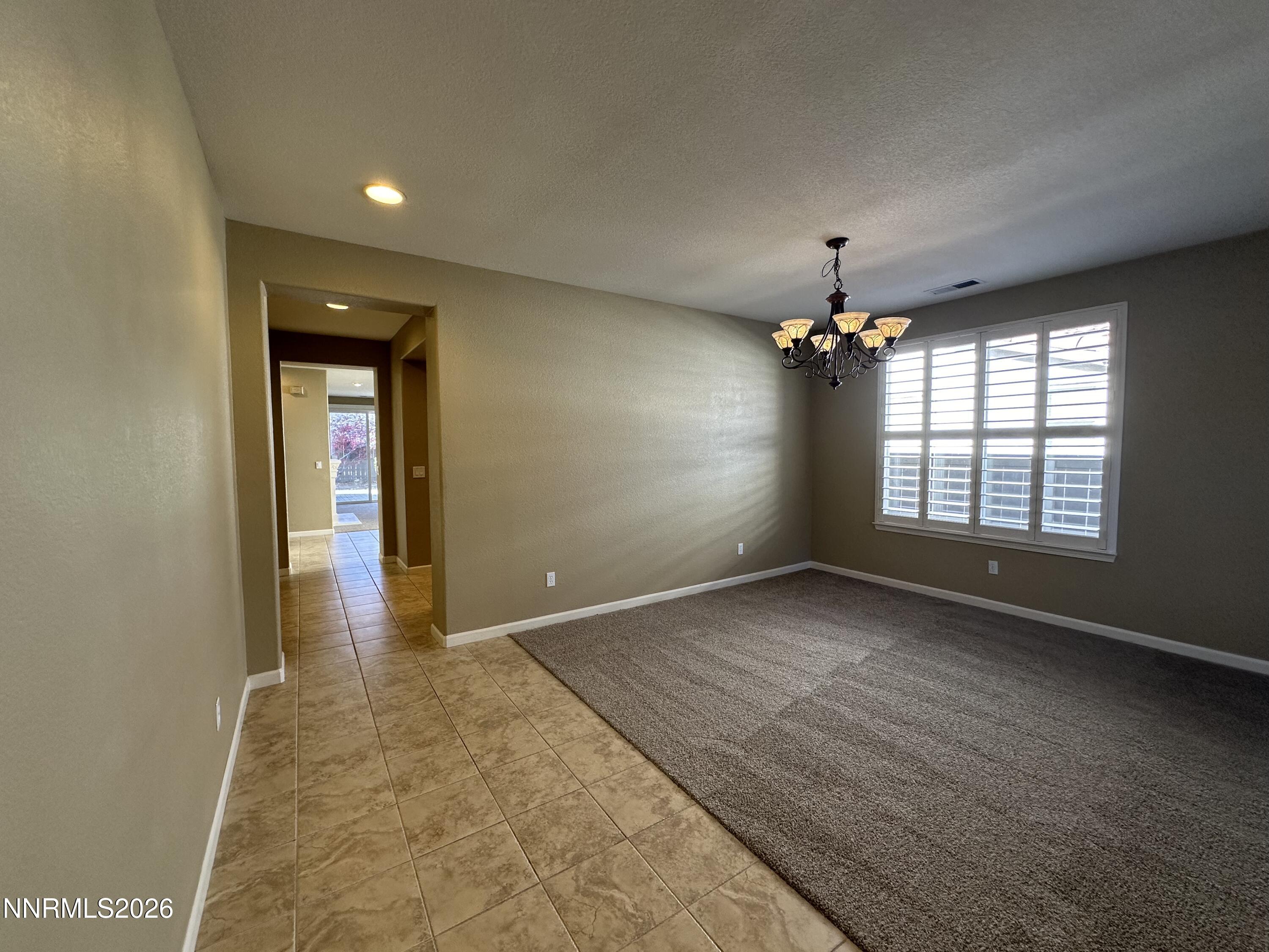 13755 Seabiscuit Drive Reno, NV 89521 - Photo 5 of 19 an empty room with windows and chandelier