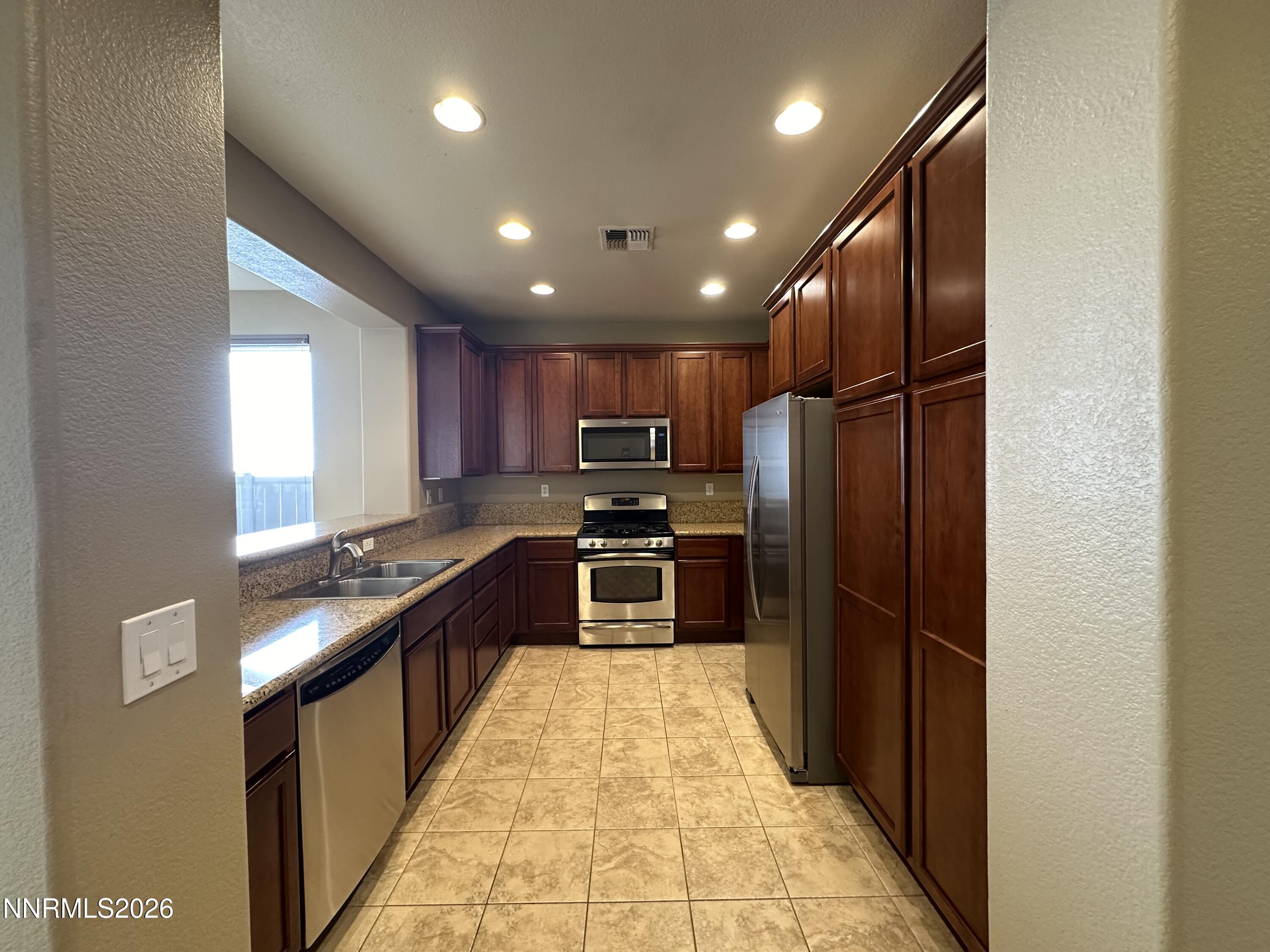 13755 Seabiscuit Drive Reno, NV 89521 - Photo 6 of 19 a kitchen with stainless steel appliances granite countertop a refrigerator and a sink