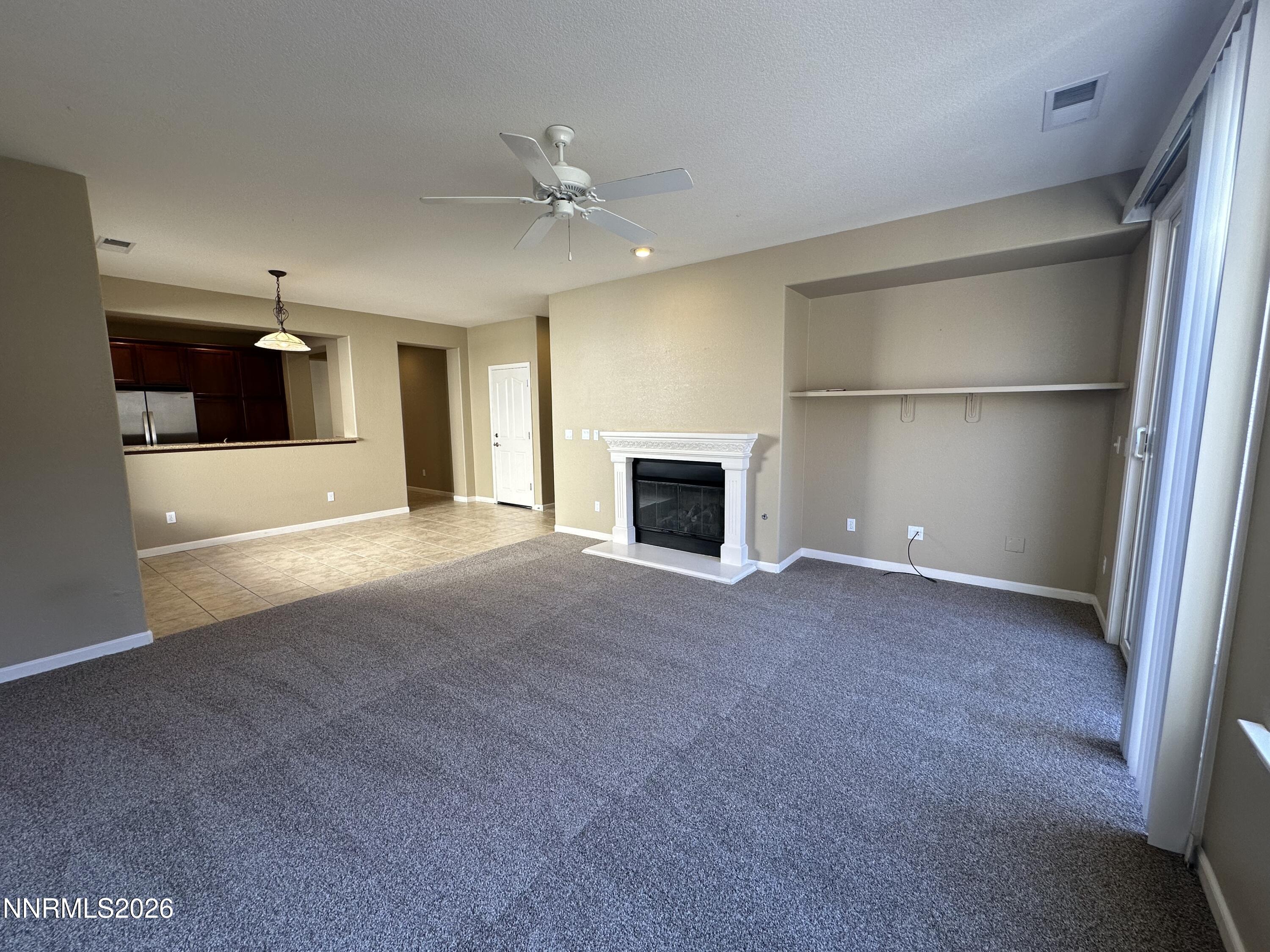 13755 Seabiscuit Drive Reno, NV 89521 - Photo 9 of 19 a view of an empty room with a fireplace and a window