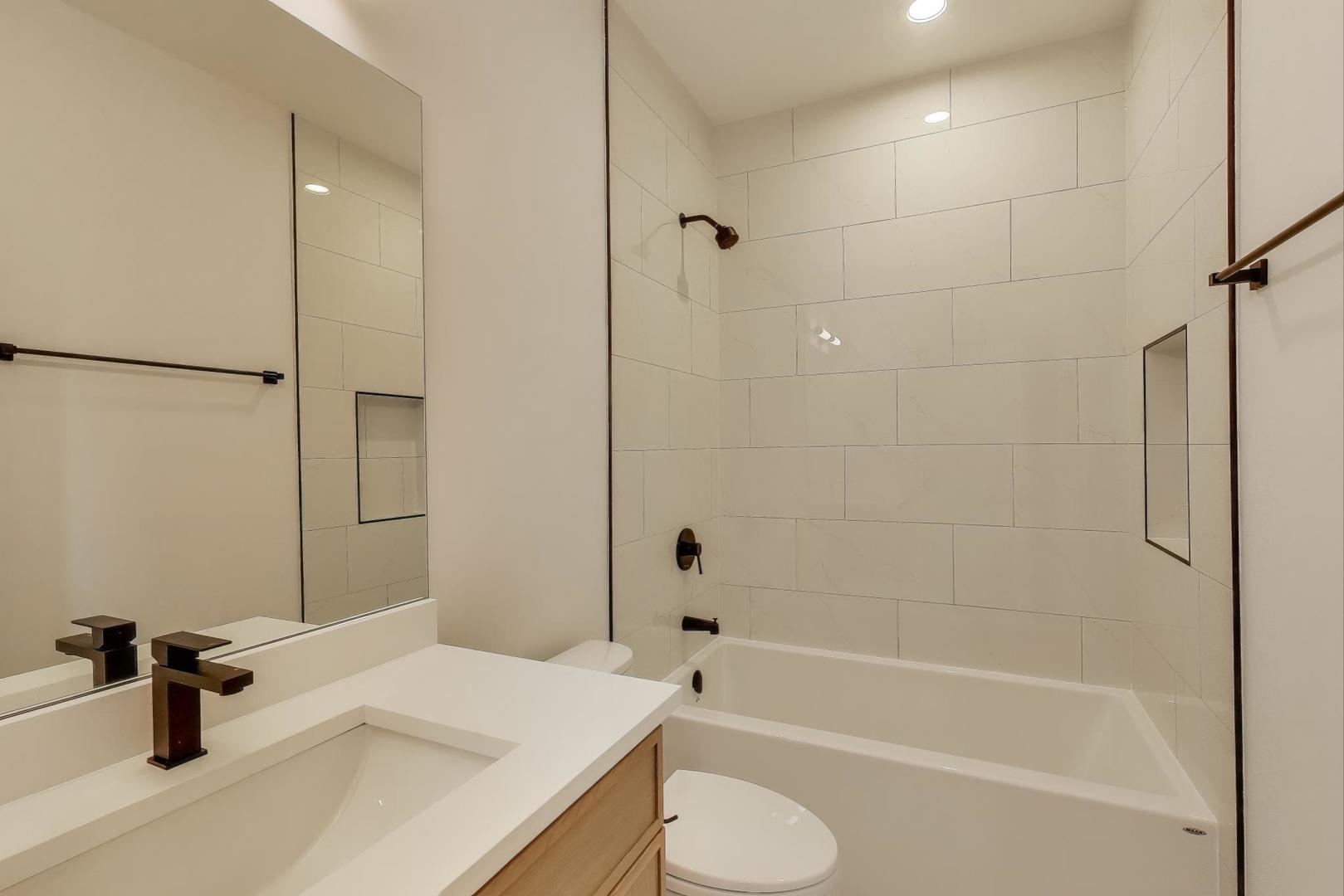 1619 West Lawrence Avenue, Unit 2 Chicago, IL 60640 - Photo 14 of 19 a bathroom with a sink a toilet and a bathtub