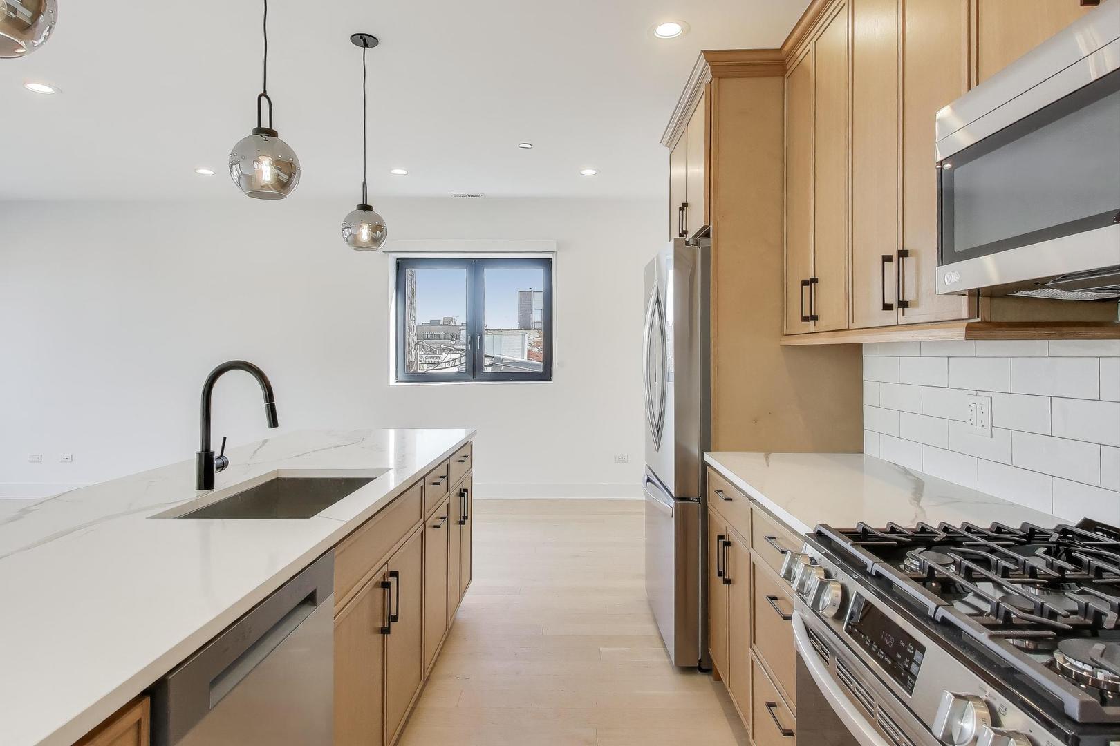 1619 West Lawrence Avenue, Unit 2 Chicago, IL 60640 - Photo 6 of 19 a kitchen with stainless steel appliances a sink stove and cabinets