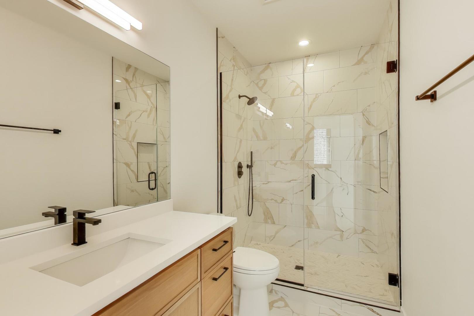 1619 West Lawrence Avenue, Unit 2 Chicago, IL 60640 - Photo 10 of 19 a bathroom with a sink toilet a mirror and shower