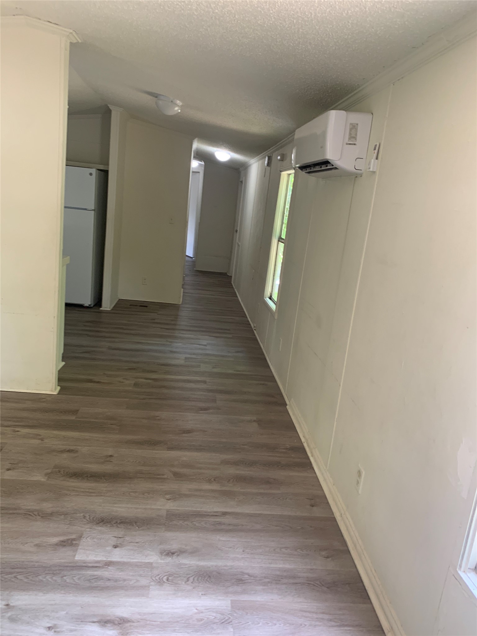 9903 Cheryl Lynn Road Austin, TX 78747 - Photo 6 of 13 A well-lit corridor with sleek plank flooring connects various functional areas.