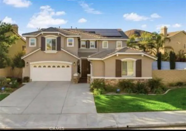 a view of a white house with a yard and large tree