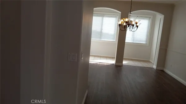 a view of a chandelier in big room with wooden floor