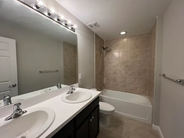 a bathroom with a granite countertop sink a toilet and shower