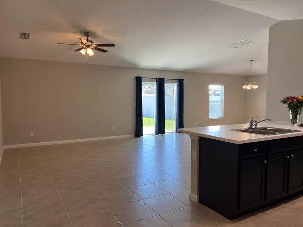 a view of a room with a sink and chandelier fan