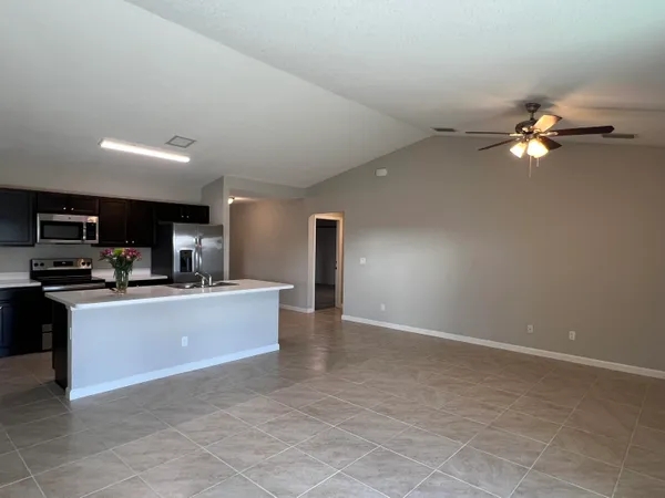 a view of living room with kitchen island stainless steel appliances wooden floor and living room view