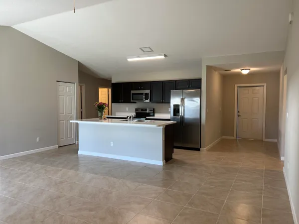 a large kitchen with kitchen island a sink stainless steel appliances and cabinets